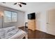 Cozy bedroom with hardwood floors, plenty of natural light and a dresser with a TV at 4129 Fabulous Finches Ave, North Las Vegas, NV 89084