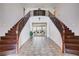 Expansive foyer with grand dual staircase, tile flooring, and views into the adjacent living room at 4129 Fabulous Finches Ave, North Las Vegas, NV 89084