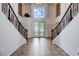 Home's foyer showcases soaring ceilings, a tile floor and dual staircases surrounding an entry door with glass inlays at 4129 Fabulous Finches Ave, North Las Vegas, NV 89084