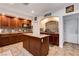 Kitchen features wood cabinets, island and mosaic tile backsplash at 4129 Fabulous Finches Ave, North Las Vegas, NV 89084