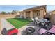 Spacious backyard with patio area, outdoor dining, fire pit, and low-maintenance synthetic lawn at 4780 Lorenzo Way, Pahrump, NV 89061