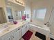 Bathroom featuring double sinks, a soaking tub, and a separate glass door shower with a large window at 4780 Lorenzo Way, Pahrump, NV 89061