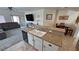 Open kitchen featuring a breakfast bar, double sink, and a view into the living room with sliding glass doors at 4780 Lorenzo Way, Pahrump, NV 89061