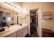 Bathroom featuring a double sink vanity, closet, and decorative shelves at 5014 Sail Rock Pl, North Las Vegas, NV 89031