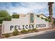 Attractive 'Pelican Creek' community sign with decorative stone accents and inviting landscaping at 5014 Sail Rock Pl, North Las Vegas, NV 89031