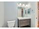 Bathroom featuring gray vanity with white sink, white toilet, and a large mirror at 508 Indian Princess Dr # 104, Las Vegas, NV 89145