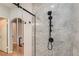 Close-up of a glass-enclosed shower with a sleek, multi-setting showerhead and gray marble tile at 508 Indian Princess Dr # 104, Las Vegas, NV 89145