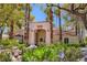 Beautifully landscaped building with desert flora and palm trees, featuring an arched entry and light stucco at 508 Indian Princess Dr # 104, Las Vegas, NV 89145