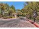 Community entrance featuring a decorative brick paved road, lush trees, and a map directory at 508 Indian Princess Dr # 104, Las Vegas, NV 89145