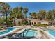 Inviting community hot tub and swimming pool area surrounded by lush trees under a clear blue sky at 508 Indian Princess Dr # 104, Las Vegas, NV 89145