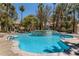 Large community pool with clear blue water and a decorative island feature surrounded by lush greenery at 508 Indian Princess Dr # 104, Las Vegas, NV 89145