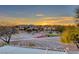 Sunset view of a property with desert landscaping, mountains, and nearby homes at 5501 Painted Sunrise Dr, Las Vegas, NV 89149