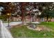 Well-kept front yard features lush green grass, mature trees, and elegant outdoor lighting at 5501 Painted Sunrise Dr, Las Vegas, NV 89149