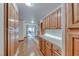 Hallway featuring wood cabinets, white countertops, wood flooring and natural light at 5501 Painted Sunrise Dr, Las Vegas, NV 89149