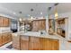 Kitchen with island cooktop, wooden cabinets, and granite countertops at 5501 Painted Sunrise Dr, Las Vegas, NV 89149