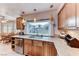 Kitchen featuring stainless steel appliances, wooden cabinetry, granite countertops, and a view of the backyard at 5501 Painted Sunrise Dr, Las Vegas, NV 89149