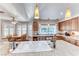 Bright kitchen with stainless appliances, light wood cabinets, granite countertops, and cooktop island at 5501 Painted Sunrise Dr, Las Vegas, NV 89149