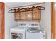 Modern laundry area with a stacked washer and dryer and upper cabinetry at 5501 Painted Sunrise Dr, Las Vegas, NV 89149