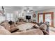 Cozy living room with a stone fireplace, hardwood floors, plantation shutters, and comfortable brown leather seating at 5501 Painted Sunrise Dr, Las Vegas, NV 89149