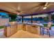 Well-equipped outdoor kitchen with a grill, refrigerator, and a sink, ideal for outdoor cooking and entertaining at 5501 Painted Sunrise Dr, Las Vegas, NV 89149