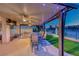 Spacious covered patio with a dining table, BBQ grill, and lush greenery, perfect for outdoor dining at 5501 Painted Sunrise Dr, Las Vegas, NV 89149