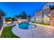 Backyard pool with a spa, lush lawn, and privacy wall with mature landscaping at 5501 Painted Sunrise Dr, Las Vegas, NV 89149