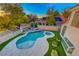 Breathtaking aerial view of a backyard with a sparkling pool, lush landscaping, and a charming patio area at 5501 Painted Sunrise Dr, Las Vegas, NV 89149