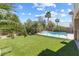 Lush backyard features green artificial turf, pool, and tall palm trees at 5578 Holcomb Bridge Ct, Las Vegas, NV 89149
