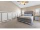 Spacious bedroom with wainscoting, soft carpet, a comfortable upholstered bed, and ample natural light at 5578 Holcomb Bridge Ct, Las Vegas, NV 89149