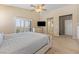 Bright bedroom with plush carpet, a ceiling fan, large window, and a TV mounted on the wall at 5578 Holcomb Bridge Ct, Las Vegas, NV 89149