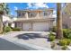 Charming two-story house featuring a two-car garage, paved driveway, and lush landscaping at 5578 Holcomb Bridge Ct, Las Vegas, NV 89149