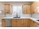 Close up of bright kitchen featuring light wood cabinets, undermount sink and white backsplash at 5578 Holcomb Bridge Ct, Las Vegas, NV 89149