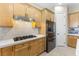 Kitchen featuring wood cabinets, stainless steel appliances and modern gas cooktop at 5578 Holcomb Bridge Ct, Las Vegas, NV 89149