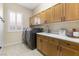 Bright laundry room with modern washer, dryer, sink, and ample cabinet space at 5578 Holcomb Bridge Ct, Las Vegas, NV 89149