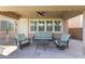 Covered patio seating area with a ceiling fan and outdoor lighting at 5578 Holcomb Bridge Ct, Las Vegas, NV 89149