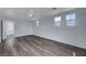 This bright bedroom has gray-toned wood flooring and natural light from three windows at 5829 Feral Garden St, North Las Vegas, NV 89031