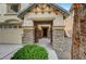 Inviting front porch with stone pillars, covered entrance and well-manicured bushes at 5829 Feral Garden St, North Las Vegas, NV 89031