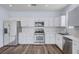 Well-equipped kitchen with stainless steel appliances, white cabinets, and a tiled backsplash at 5829 Feral Garden St, North Las Vegas, NV 89031