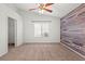 Bedroom featuring a wood accent wall, ceiling fan, and a window overlooking the neighborhood at 6037 Soft Springs Ave, Las Vegas, NV 89130