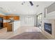 Bright, open living area featuring neutral tile, fireplace, ceiling fan and adjacent kitchen at 6037 Soft Springs Ave, Las Vegas, NV 89130