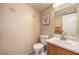 Neutral bathroom with a pedestal sink, toilet, and decorative artwork on the wall at 6066 El Sol Dr, Las Vegas, NV 89142