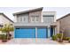 This modern two-story home features a stone facade and bright blue garage doors at 618 Steep Canyon Ave, Las Vegas, NV 89183