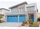 Contemporary home with blue garage doors and stone accents on the exterior facade at 618 Steep Canyon Ave, Las Vegas, NV 89183