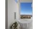 Elegant bathroom featuring a modern soaking tub and stunning mountain views from the large window at 629 Majestic Rim Dr, Henderson, NV 89012