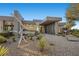Contemporary home with a unique silver sculpture, desert landscaping, and a modern, inviting entrance at 629 Majestic Rim Dr, Henderson, NV 89012