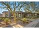 Modern home with desert landscaping featuring yucca and cactus, complemented by mature trees and a stone walkway at 629 Majestic Rim Dr, Henderson, NV 89012