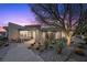 Stunning modern home exterior featuring desert landscaping and a unique architectural design at sunset at 629 Majestic Rim Dr, Henderson, NV 89012