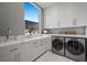 Modern laundry room equipped with sleek cabinetry, marble countertops, and stainless-steel appliances at 629 Majestic Rim Dr, Henderson, NV 89012