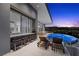 Luxurious outdoor patio with bar seating, lounge chairs, and an infinity pool overlooking mountain views at 629 Majestic Rim Dr, Henderson, NV 89012