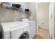 Bright laundry room with modern washer and dryer, and convenient shelving for storage at 6325 Snap Ridge St # 102, North Las Vegas, NV 89081
